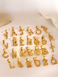 Macro shot of 26 golden bamboo texture alphabet pendants with matching bail charms