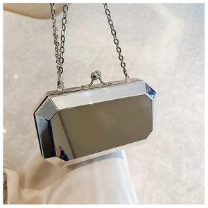 Macro detail of silver acrylic evening clutch with geometric facets and metal chain