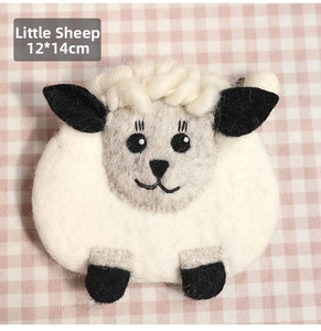 Macro shot of 12x14cm handmade little lamb wool felt coin purse on checkered fabric