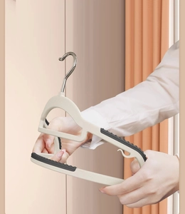 Close-up of flexible beige clothes hanger showing high durability and non-slip rubber grips