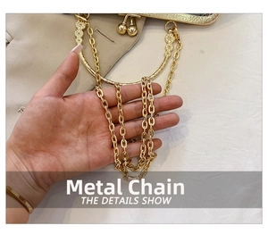 Detail of high-polish golden metal chain strap and retro engraved bag frame