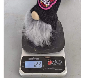 Detailed close-up of a Halloween gnome plush decoration on an electronic scale weighing 123g