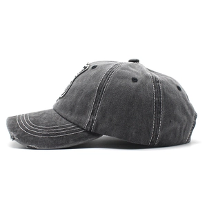 Detail of vintage washed charcoal baseball cap with distressed brim and embroidered eyelets