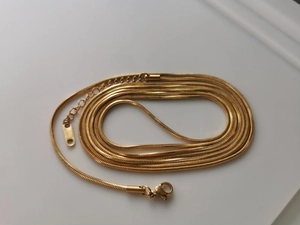 Detail of 18K gold-plated snake chain showing woven texture and spring clasp closure