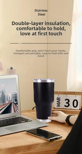 Insulated black stainless steel tumbler with spill-proof lid on office desk setting