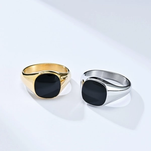 Detailed view of titanium steel signet rings with black enamel inlay in gold and silver