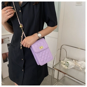 Close-up of lavender quilted crossbody bag with gold twist lock and chain strap