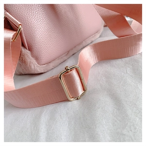 Detail of pink backpack strap showing lychee grain leather, plush trim, and metal buckle