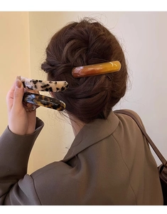 Chic tortoiseshell acetate spring hair clip shown in a stylish updo on brown hair