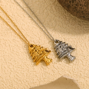 Detail of gold and silver Christmas tree pendant necklaces on natural stone props