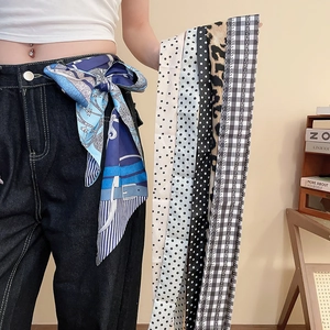 Dettaglio di cinture in seta con vari motivi come pois e stampe leopardate per accessori