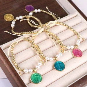Detailed view of colorful enamel medals and pearl beaded bracelets in a jewelry box
