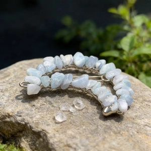Macro shot of handmade moon hair clip with blue aquamarine stones on a rustic rock