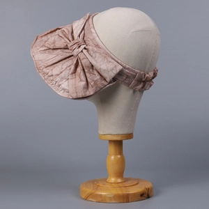 Detail of elegant sun hat featuring a large pink bow and pleated fabric texture