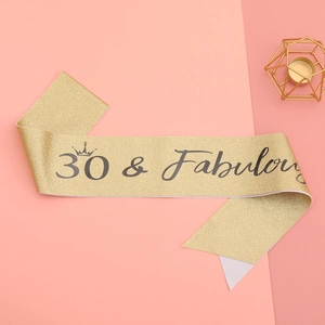 Close-up of 30 & Fabulous gold glitter sash with crown detail for 30th birthday parties