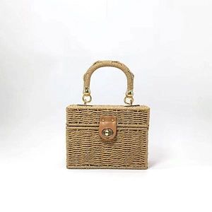 Detail of woven straw handbag featuring a natural fiber texture and golden twist lock