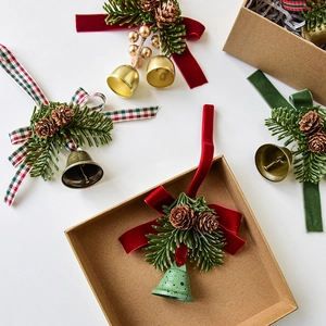Christmas ornaments set with pine cones bells and velvet ribbons in a kraft gift box