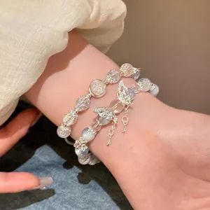Double-layered beaded bracelet with butterfly charms and crystal beads on female wrist