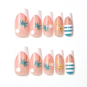 Detail of French pink and white press-on nails with palm tree and floral patterns