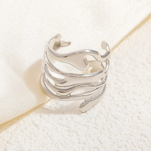 Close-up of a silver irregular multi-layer wavy open ring on beige textured fabric