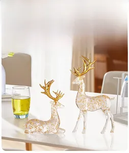 Detail of luxury transparent elk figurines with gold foil fragments and golden antlers