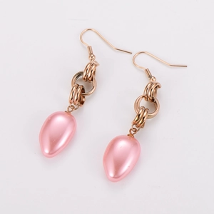 Dettaglio di orecchini a catena ritorta in oro rosa con perle rosa a goccia su bianco