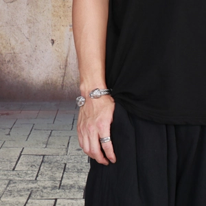 Close-up of punk style silver steel lion head cable bracelet and textured ring for men