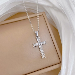 Detailed view of silver titanium steel cross pendant necklace with sparkling zircons