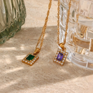 Detail of square zircon necklaces with emerald and violet stones on gold rope chains