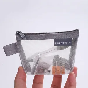 Gray nylon mesh triangle coin purse with zipper and side strap held in hand