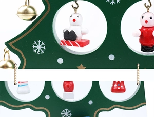 Detailed view of handmade green wooden Christmas tree with mini figurines and gold bells