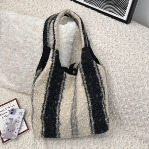 Detail of black and white fuzzy tote bag showing plush texture and metal snap closure