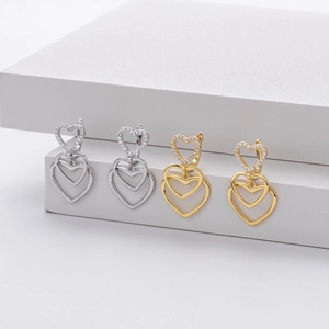 Close-up of triple heart drop earrings in gold and silver with S925 hallmark detail