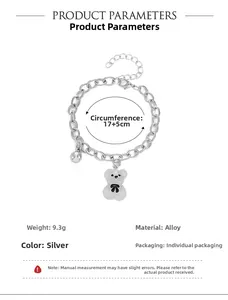 Detailansicht eines silbernen Bärenarmbands mit weißem Glitzerbär und schwarzer Schleife