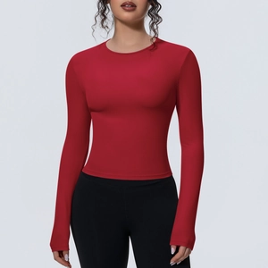 Détail d'un haut de yoga rouge à manches longues, coupe ajustée et tissu mat respirant