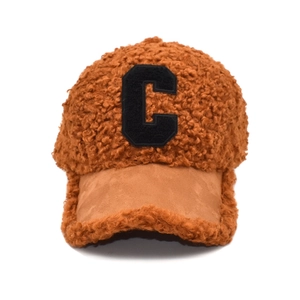 Detail of brown teddy fleece baseball cap with black letter C patch and suede brim