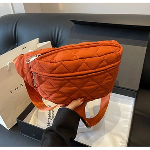 Close-up of orange quilted nylon crossbody bag showing the premium texture and zipper detail
