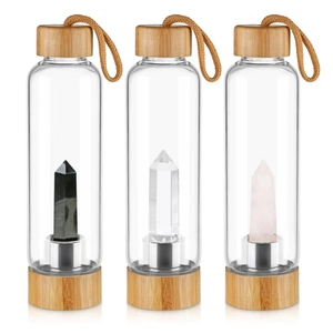 Three glass water bottles featuring black, clear, and pink hexagonal crystal columns with bamboo lids
