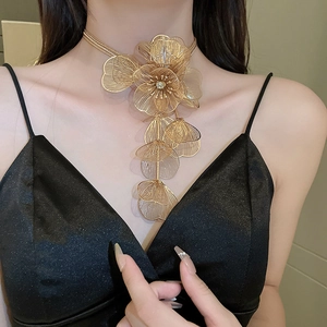 Close-up of golden mesh floral choker necklace with tiered fringe and crystal accents