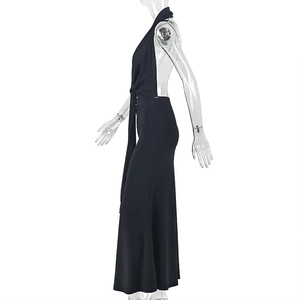 Side view of black halter backless maxi dress with pleated details on a model