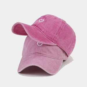 Washed cotton baseball caps with embroidered hearts in magenta and soft pink tones