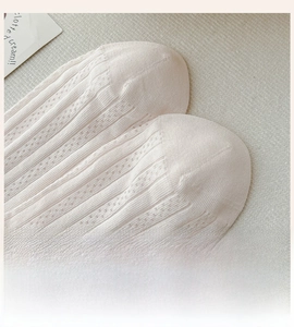 Detailed macro view of the seamless flat toe stitching on beige breathable knit socks