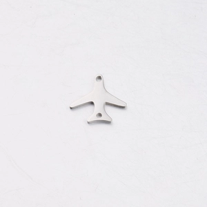 Macro shot of mirror polished stainless steel airplane pendant with double holes