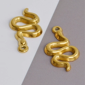 Detailed close-up of two golden 304 stainless steel snake charms with textured scales