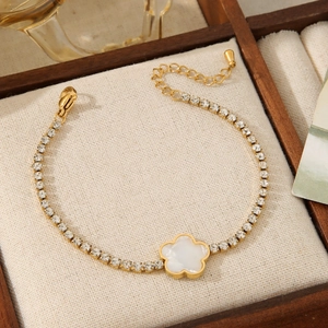 Elegant gold bracelet with white flower pendant and rhinestones in a luxury wood box