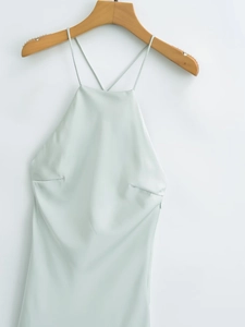 Detail of mint green satin dress featuring a halter neck and delicate pleated bodice