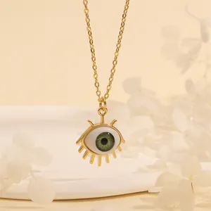 Close-up of 18K gold evil eye necklace with green iris and radial gold eyelash detail