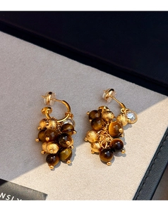 Detailed macro view of gold beaded cluster earrings with brown tiger eye stones
