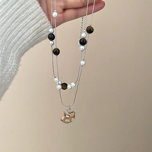 Vue détaillée du collier argenté double couche avec perles, œil de tigre et pendentif cheval