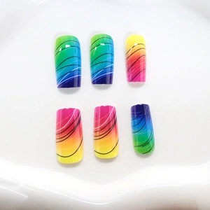 Rainbow gradient long press-on nails with black wavy lines and a glossy candy finish